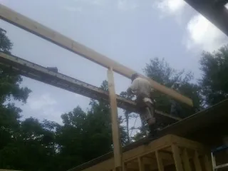 Carpenter setting a ridge beam over a new addition frame — Ice Dam Removal by Roofing Brothers in Abbeville